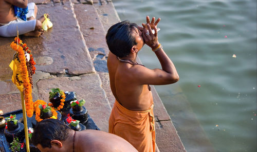 Rear view of shirtless man in water