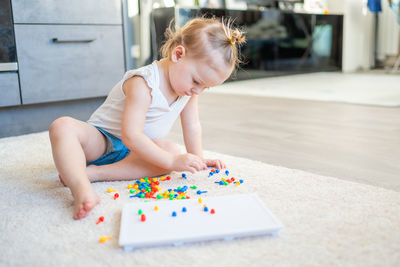 Cute girl playing with multi colored toy at home