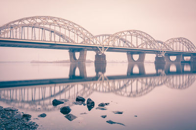 New darnytskyi bridge over dnieper river with reflection against sky