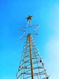 Low angle view of crane against clear blue sky
