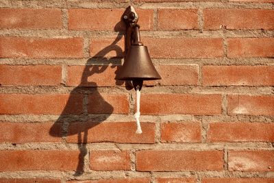 Close-up of electric lamp on brick wall