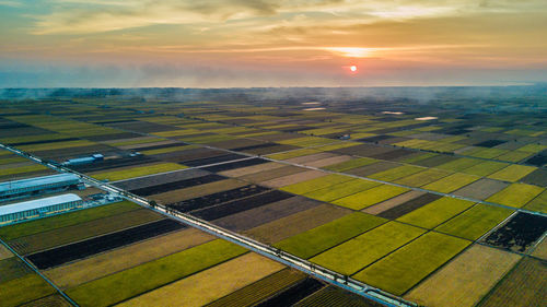 Aerial view of agricultural field against sky during sunset