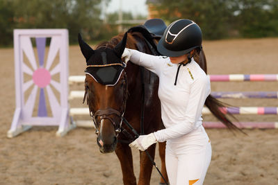 Full length of woman riding horse on field