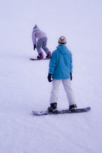 Rear view of people on snow covered land