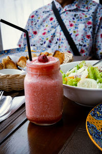 Strawberry shake, vegetable salad and bread on the table.