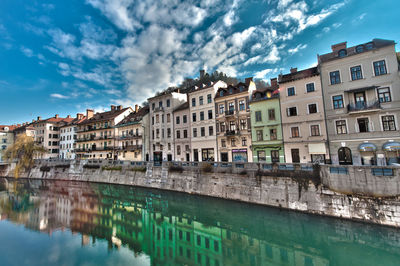 Buildings in city against cloudy sky