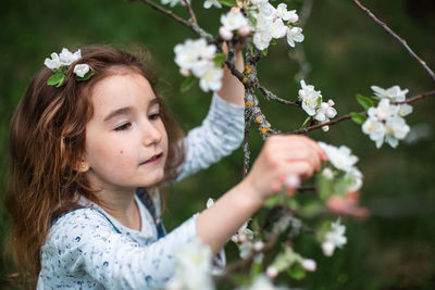 Portrait of young woman blowing flowers