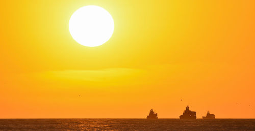 Scenic view of sea against orange sky