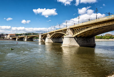 Margaret bridge over danube river against sky in city