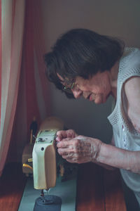 Senior woman working on sewing machine