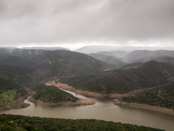 Scenic view of river and mountains against sky