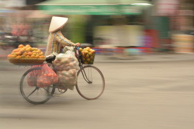 Vendor carrying fruits in bicycle on road