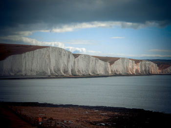 Scenic view of sea and mountains against sky