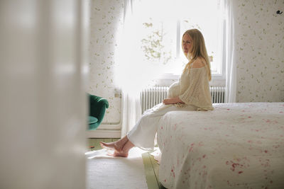 Pregnant woman sitting in bedroom