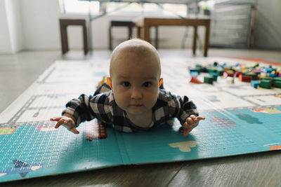 Cute baby girl playing with a toy on a play mat.