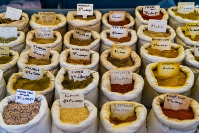 High angle view of spices with labels in sacks at market stall