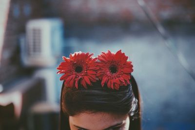 Close-up of woman with red flower