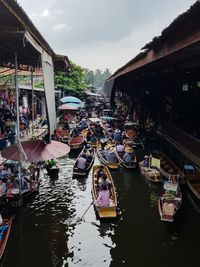 Boats moored in water against sky