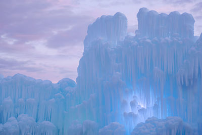 Panoramic view of ice castles against cloudy sky