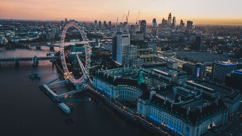 High angle view of illuminated buildings in city during sunset