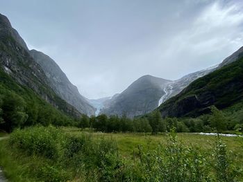 Scenic view of green landscape and mountains against sky