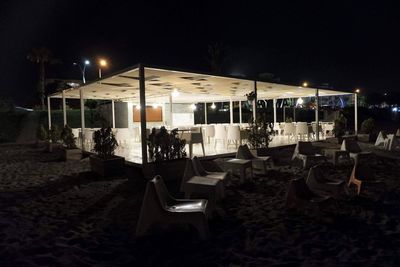 Empty chairs on street at night