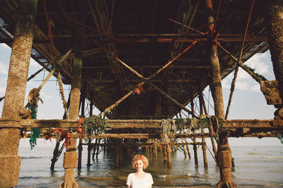 Woman standing below eastbourne pier at beach