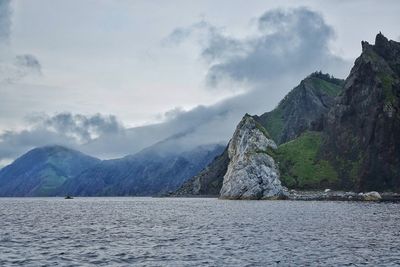 Idyllic shot of mountains and sea against sky