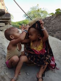 Mother and girl sitting outdoors