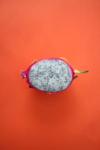 Close-up of halved dragon fruit against red background