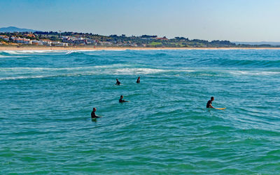 People in sea against sky