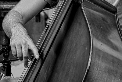 Cropped hand of man playing double bass