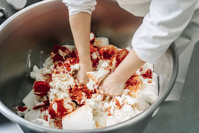 Skilled chef kneading cheese and ingredients in machinery at factory