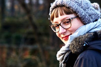 Portrait of woman wearing hat against trees during winter