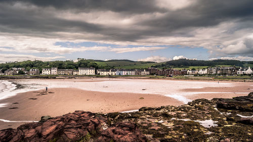 Scenic view of beach by buildings against sky