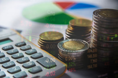 Double exposure of financial figures with coins and calculator