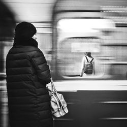 Rear view of woman standing in train