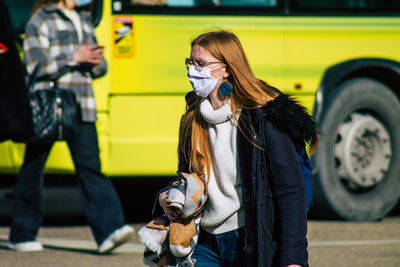 Woman holding dog standing outdoors