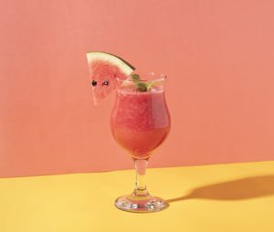 Close-up of drink on table against red background