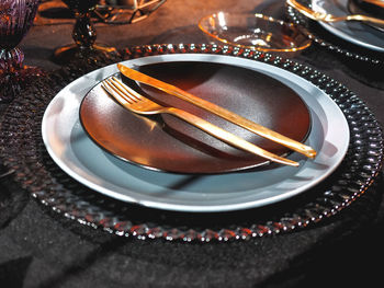Table served in halloween style.gothic vine glasses, plates on black tablecloth.holiday decoration.