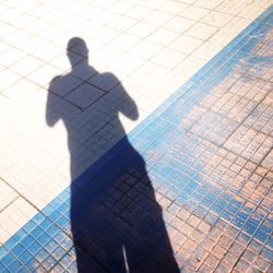 Low section of silhouette person standing by swimming pool
