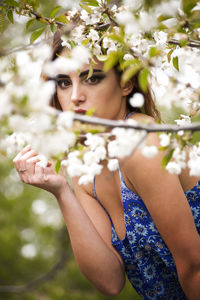 Portrait of woman holding flowering plant