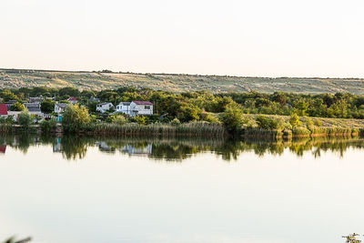 Scenic view of lake by building against clear sky