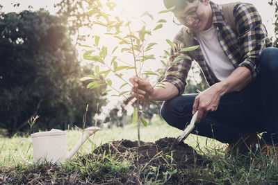 Man planting plant in yard