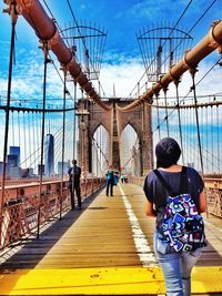 Person walking on bridge against clear sky