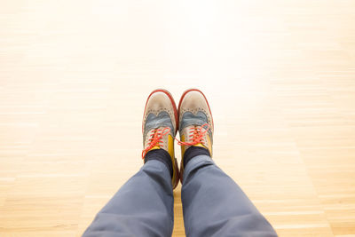 Low section of person standing on hardwood floor