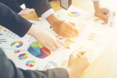 Close-up of businessman and colleague working over graph on table