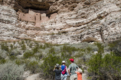 Rear view of people walking on rock formation