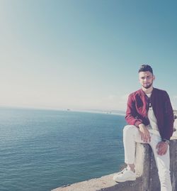 Portrait of young man against sea against clear sky