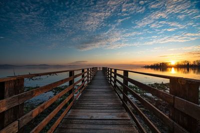 Pier over sea against sky during sunset